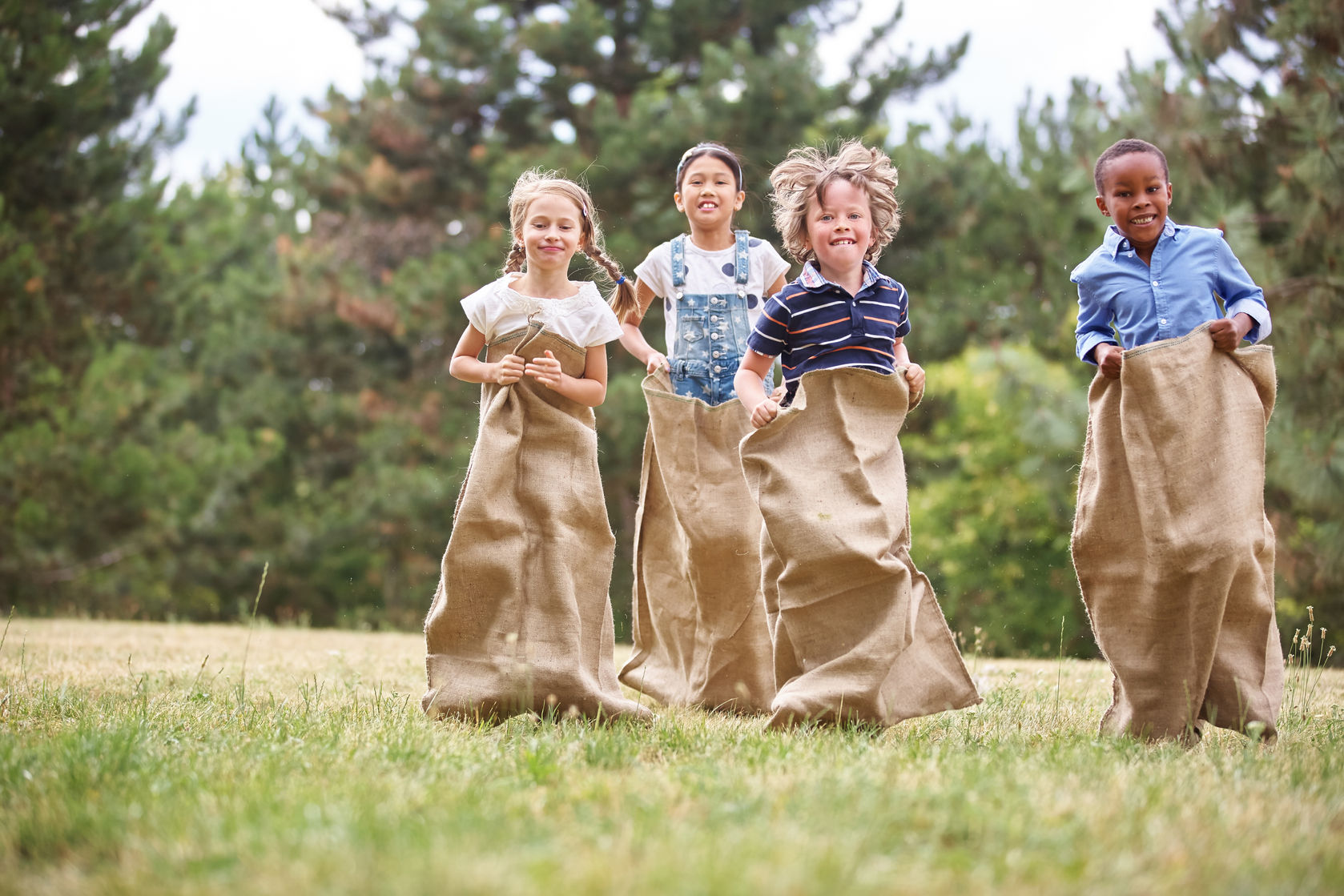 Des enfants font une course en sac