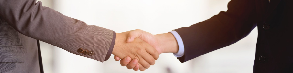 Deux personnes se serrant la main représentant un accord suite à une négociation entre le syndic et le président de conseil syndical