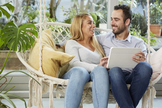 Un couple regarde une tablette