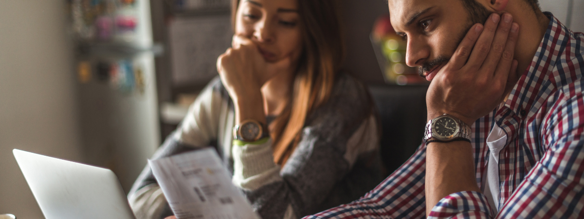 Couple de copropriétaires subissant des retards de paiement représentant l'élargissement des pénalités de retard de paiement avec la loi Elan en copropriété