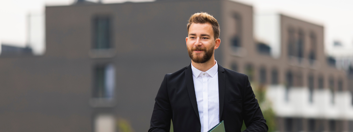 Une personne en costume devant un immeuble