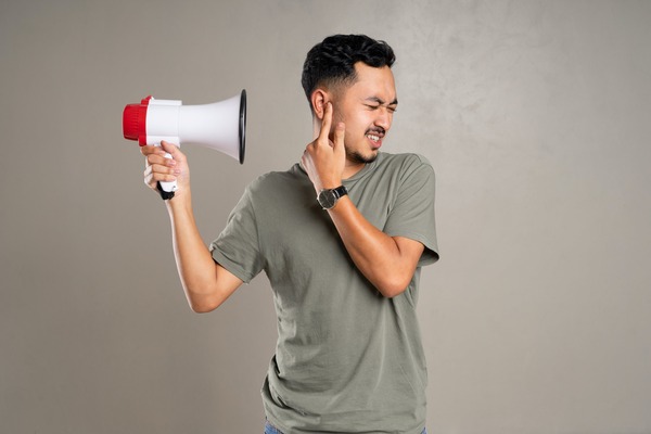 Une personne est gênée par un mégaphone